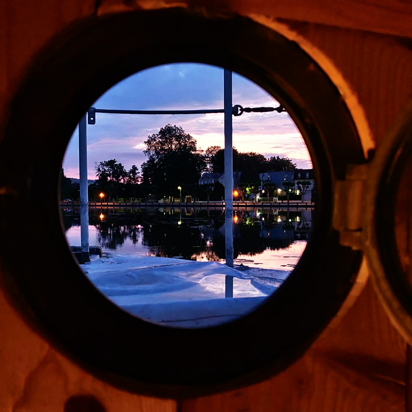 Vue à travers un hublot en bronze au crépuscule